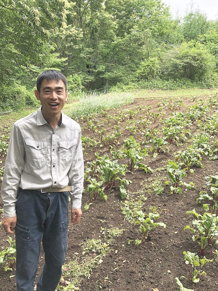 ファームさいかち：畑に立つファームさいかちの生産者