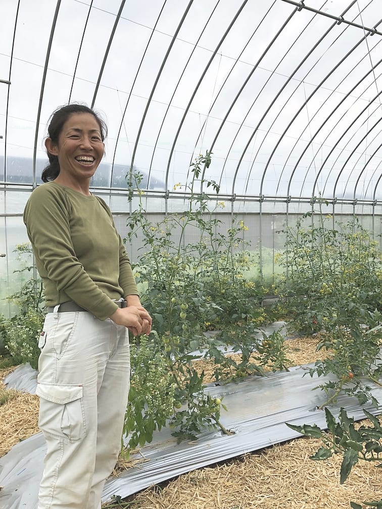 Uファーム 中澤農園：温室で笑顔を見せる中澤農園の生産者