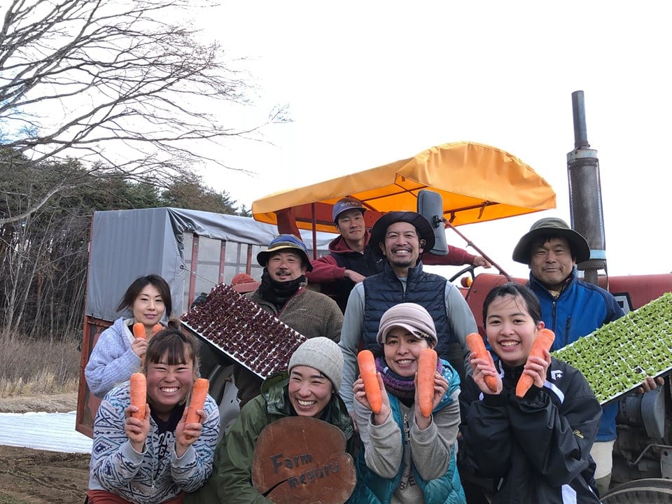 Farmめぐる：人参や苗を手に笑う Farm めぐるのメンバー