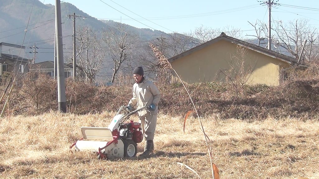サニーファーム（笠井農園）：畑で耕運機を使って作業するサニーファームの生産者